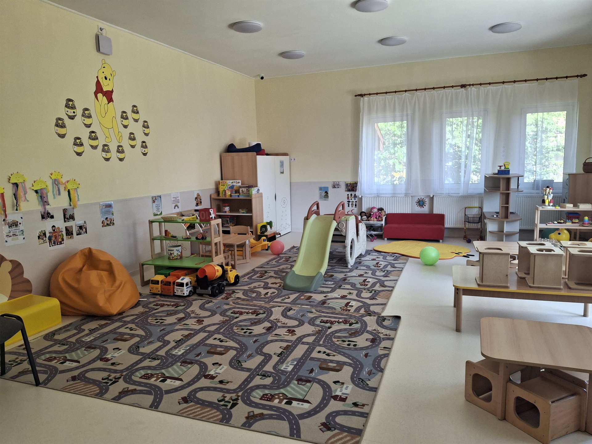 Tágas, napfényes csoportszoba játékokkal és gyermekbútorokkal